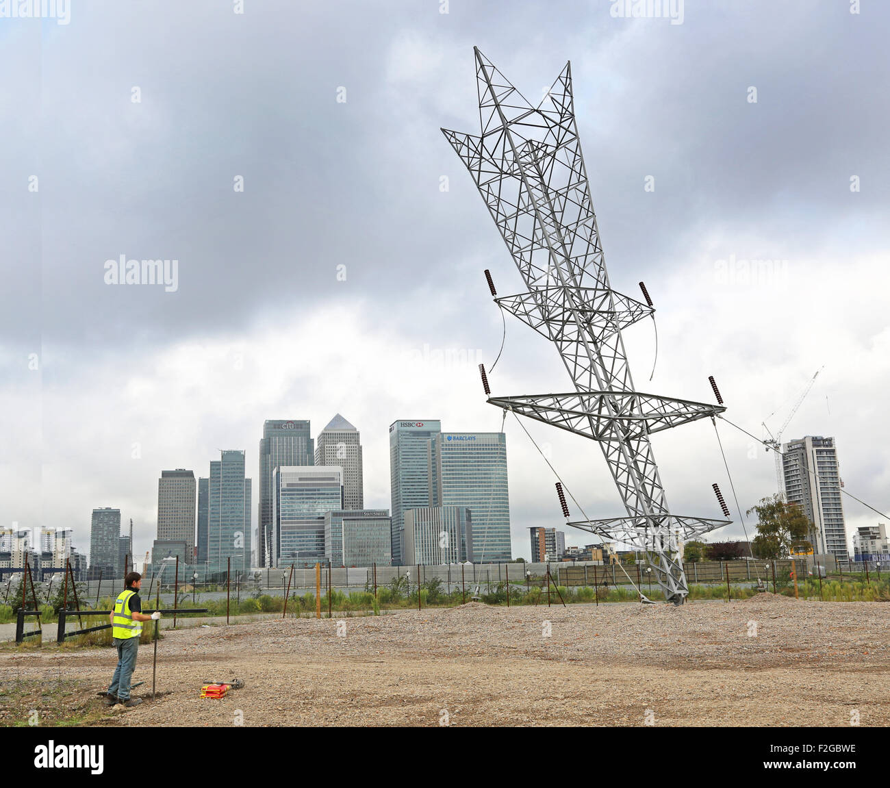 Alex Chinneck eine Kugel aus einer Sternschnuppe, Halbinsel Greenwich, London. Ein full-Size-Strommasten berührt den Boden Stockfoto