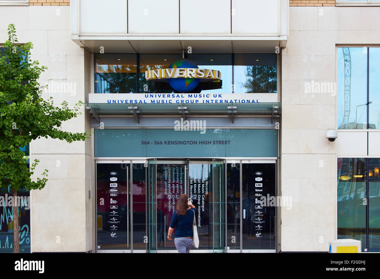 LONDON, UK - 17. AUGUST: Frau nähert sich Eingang von Universal Music Group International Gebäude in Kensington High Street. Au Stockfoto