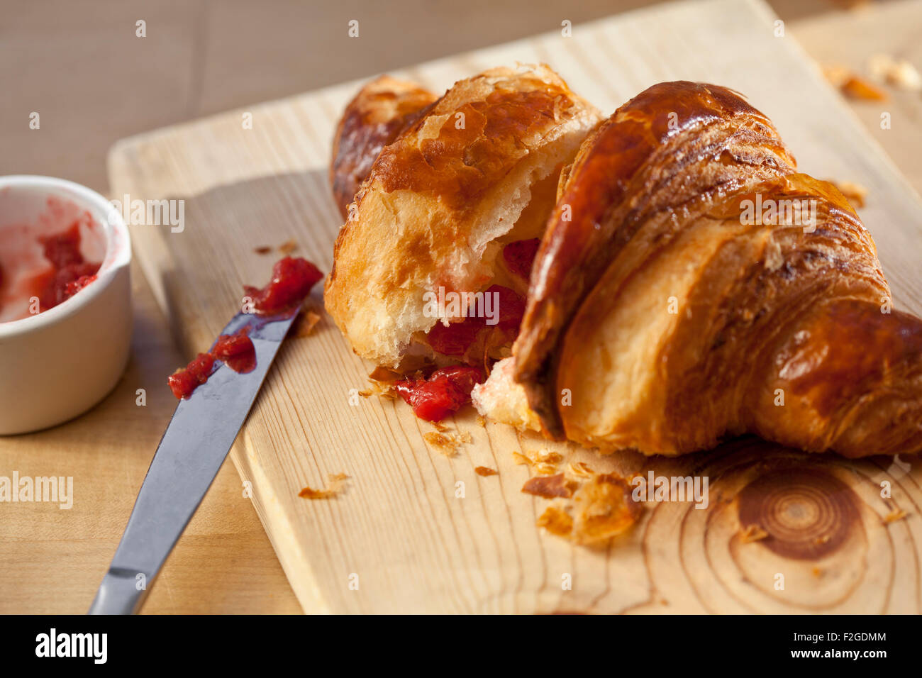Croissant in natürlichem Licht mit Erdbeermarmelade Stockfoto