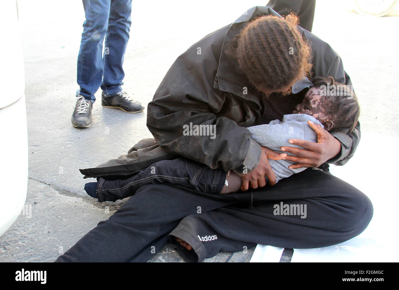 Tripoli, Libyen. 18. Sep, 2015. Ein Migrant hält ein totes Kind am Hafen von Tripolis, in Libyen, am 18. September 2015. Eine libysche Öltanker gerettet eine Gruppe von Migranten vor der Küste von Tripolis am Freitag. Mindestens sieben Leichen wurden geborgen, darunter ein Kind. © Hamza Türkei/Xinhua/Alamy Live-Nachrichten Stockfoto