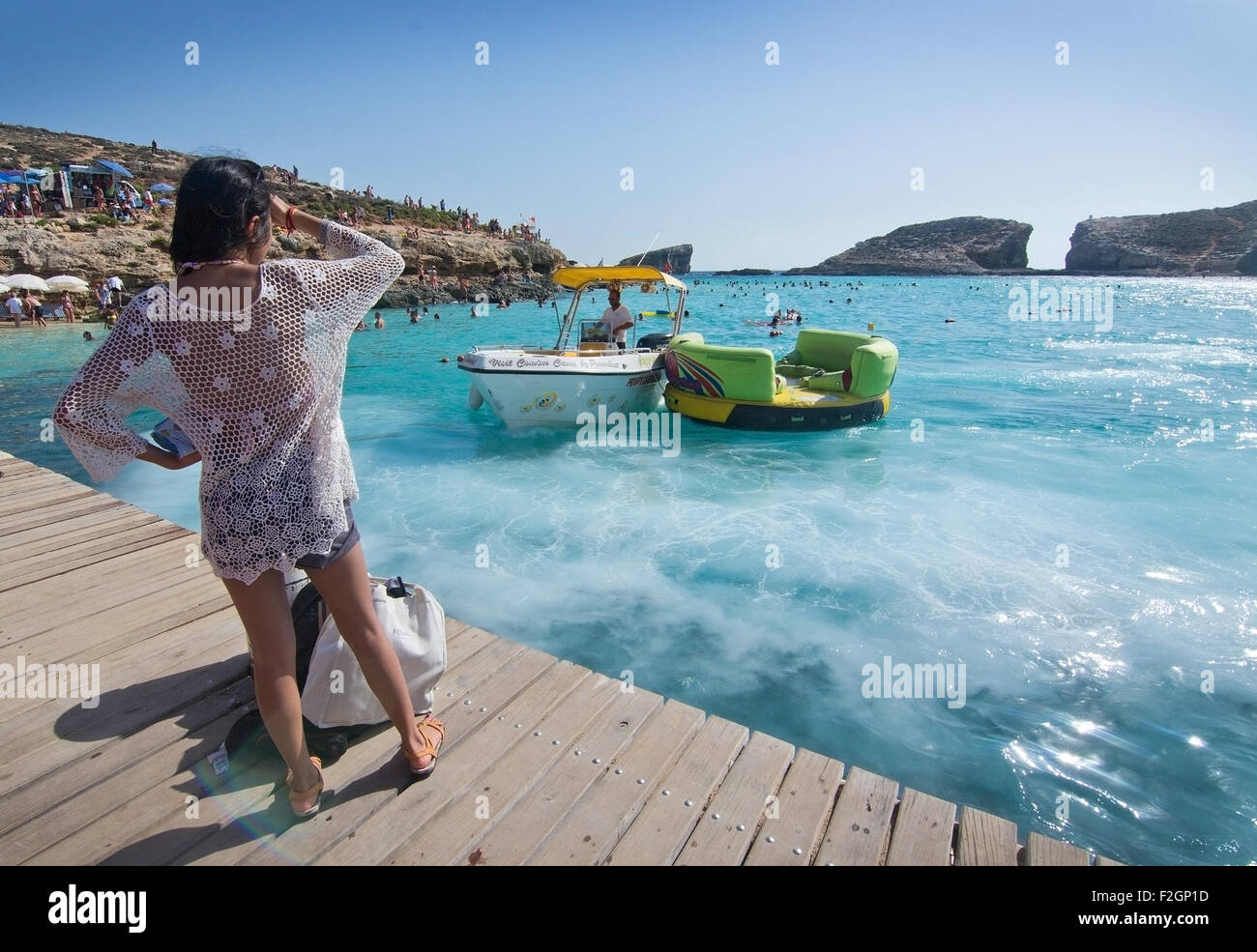 BLAUE Lagune, COMINO, MALTA - 16. September 2015: Junge Frau wacht Boote Schaumbildung im klaren, türkisfarbenen Wasser des beliebten touri Stockfoto