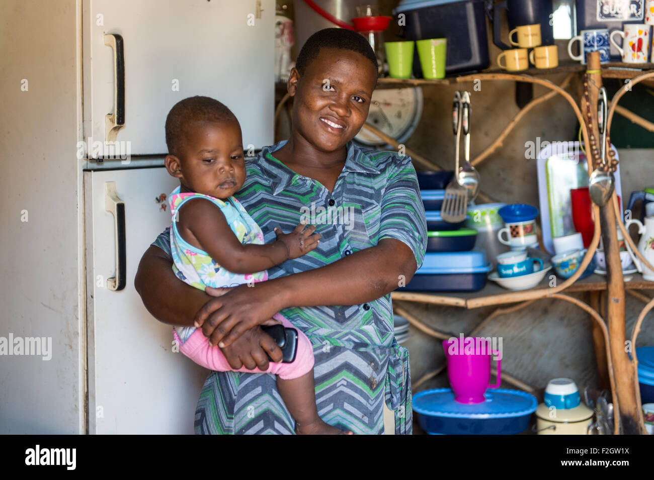 Afrikanische Mutter Holding Kleinkind in ihrer Küche in Botswana, Afrika Stockfoto