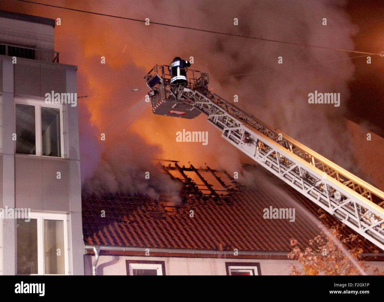 Feuerwehrleute kämpfen ein Feuer in einem Haus in Pforzheim, Deutschland, in der Nacht vom 19. / 20. Oktober 2015. Ersten Berichten zufolge vier Todesopfer und Verletzte in das Feuer im Haus, die vor allem von Einwanderern bewohnt war. Die Polizei sagt, dass bisher gibt es keinen Hinweis auf ein fremdenfeindliches Motiv für den Angriff. FOTO: GRESS/DPA Stockfoto