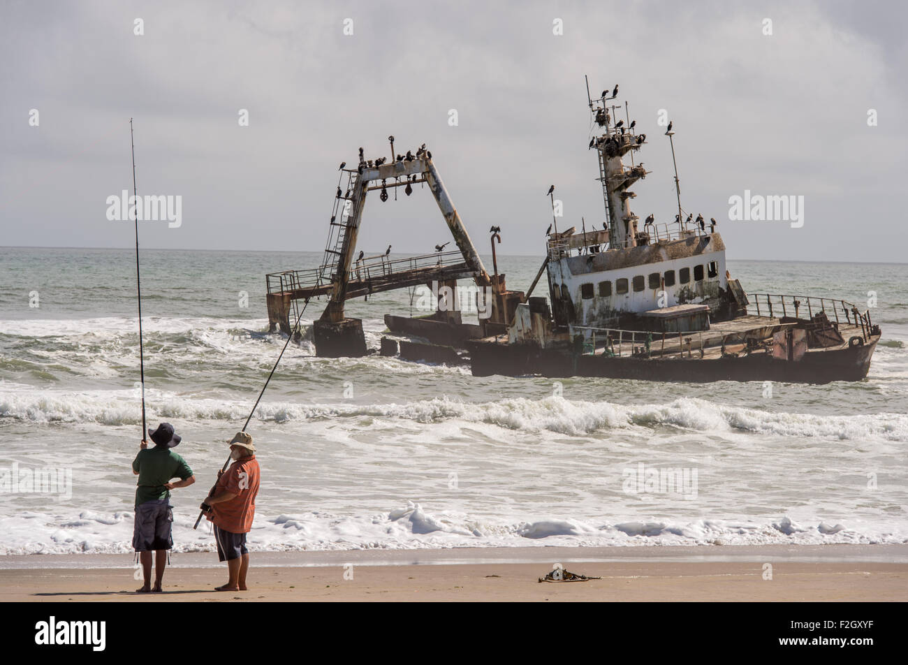 Männer Angeln in der Nähe von einem Schiffbruch an der Skelettküste in Namibia, Afrika Stockfoto
