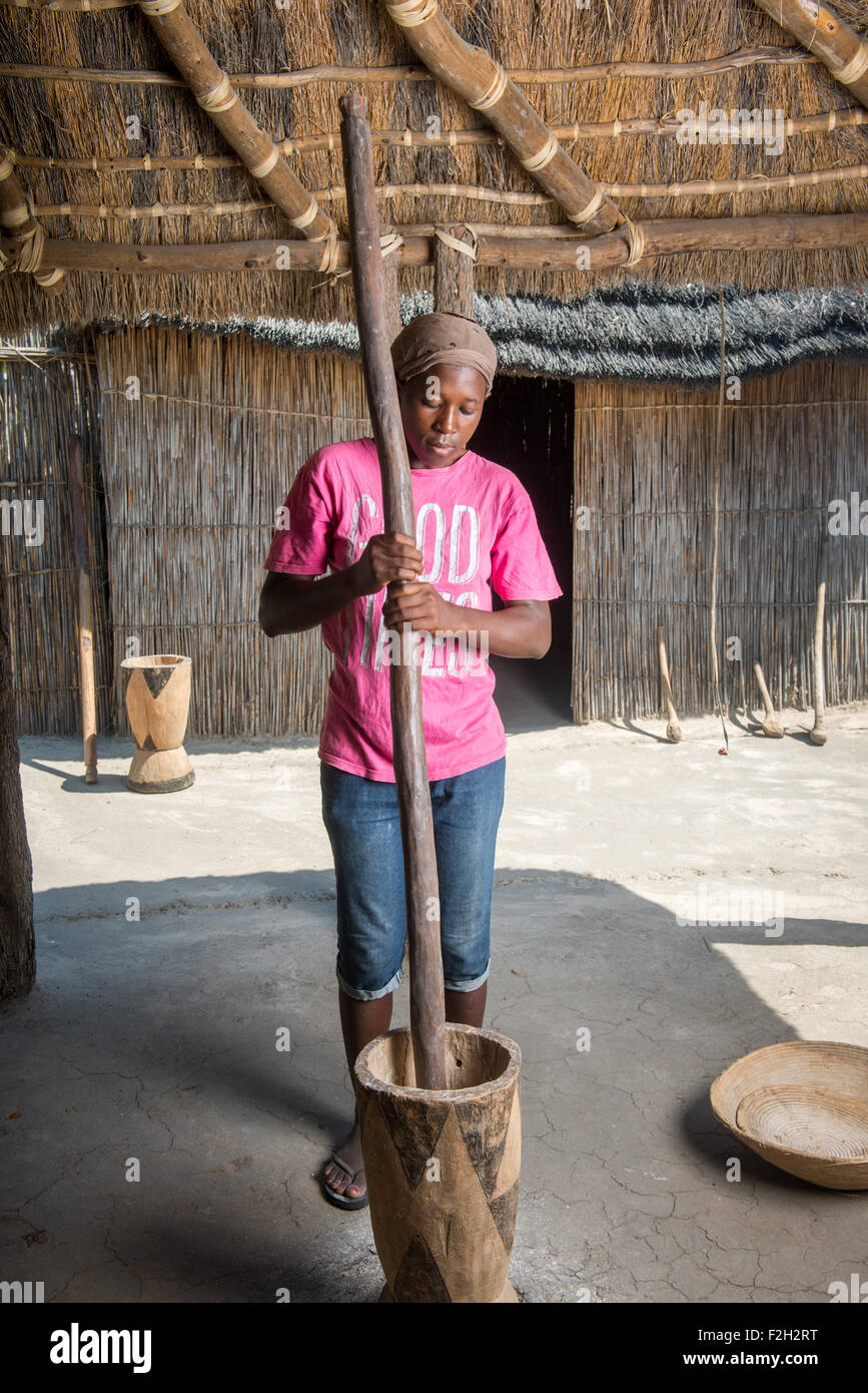 Afrikanerin mit großen Mörser und Stößel in Sexaxa Dorf in Botswana, Afrika Stockfoto