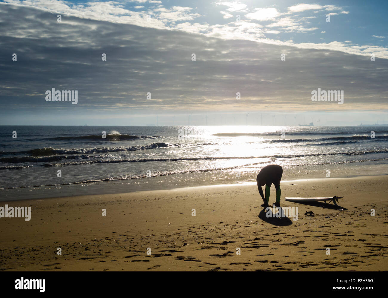 Surfer bei Sonnenaufgang am Strand von Seaton Carew dehnen. Nord-Ost-England. Vereinigtes Königreich Stockfoto