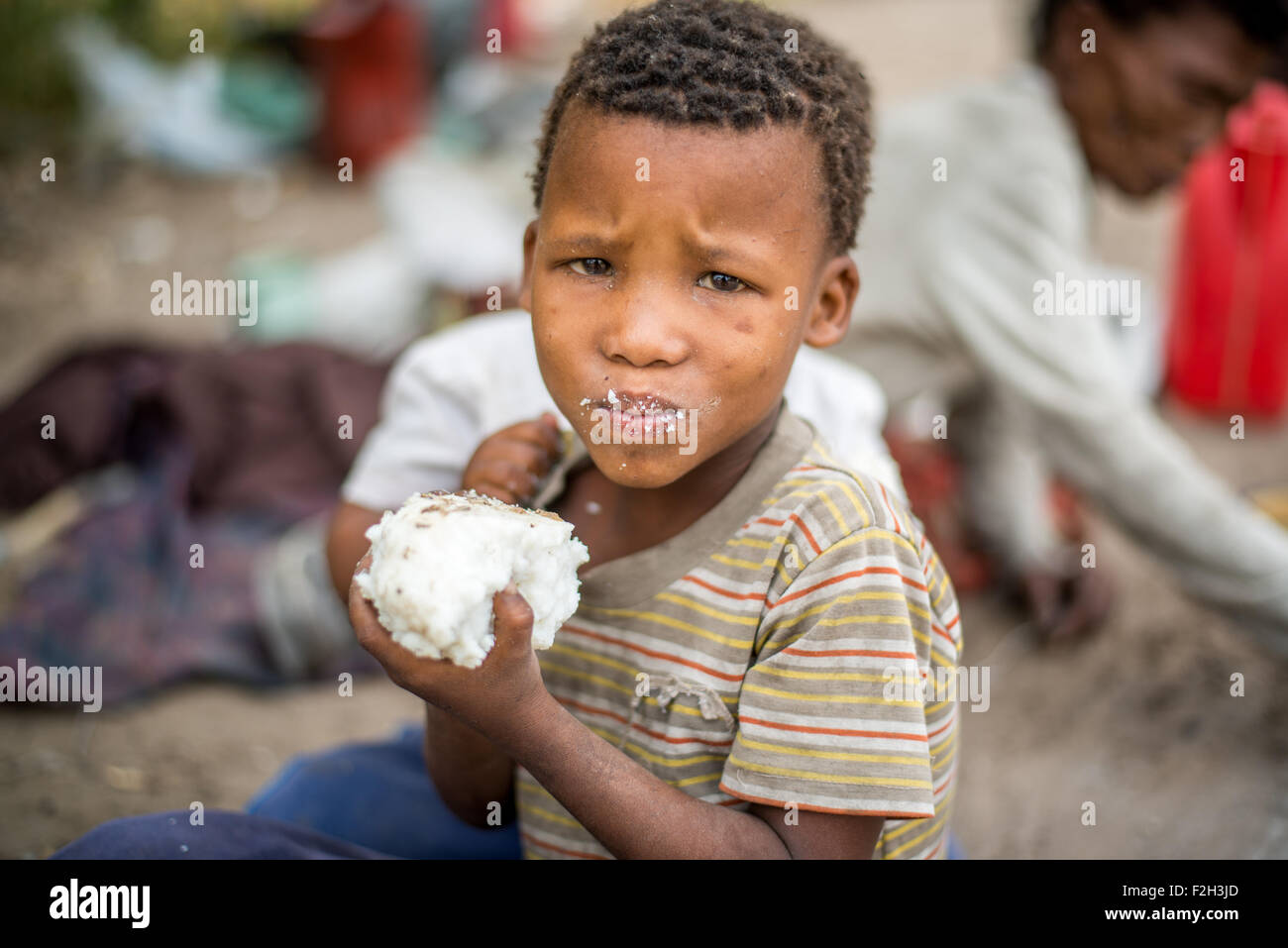 Kleiner Junge Essen Hirse in Botswana, Afrika Stockfoto
