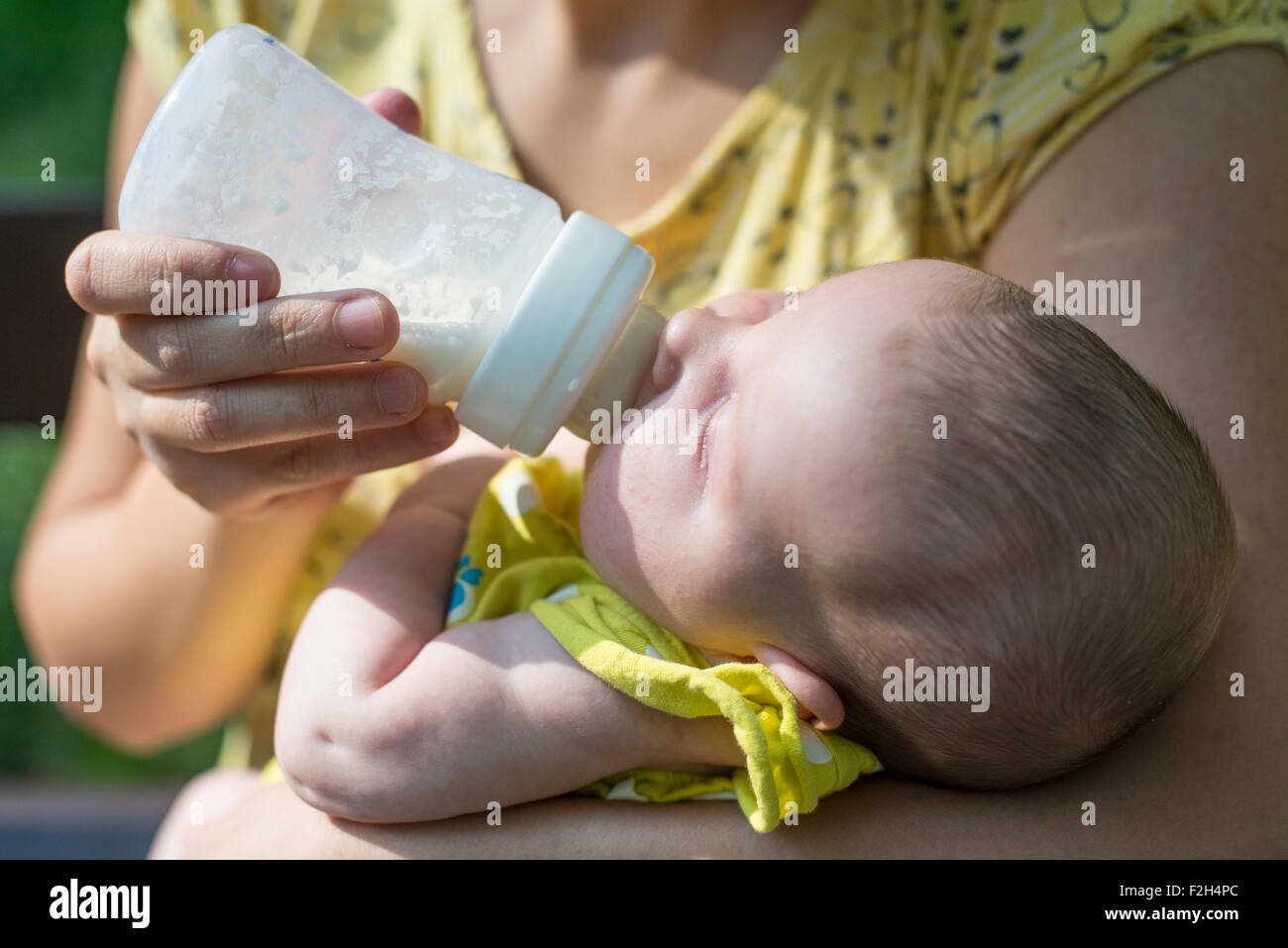 Baby saugt an einer Flasche. Baby in Mutters Händen Stockfoto