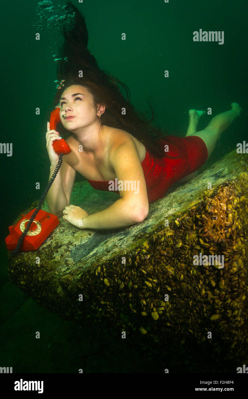 Mädchen am Telefon unter Wasser Stockfoto