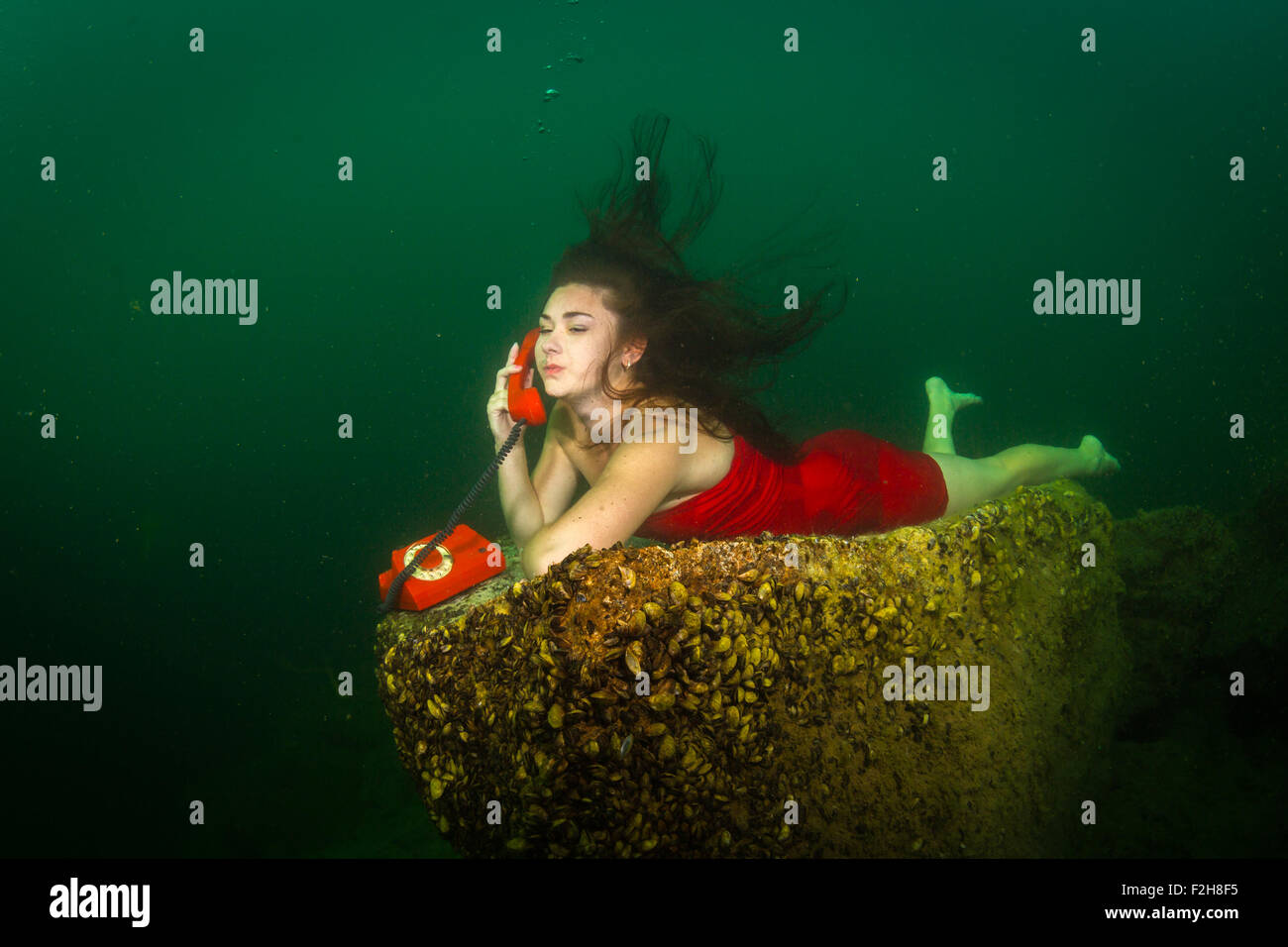 Mädchen am Telefon unter Wasser Stockfoto