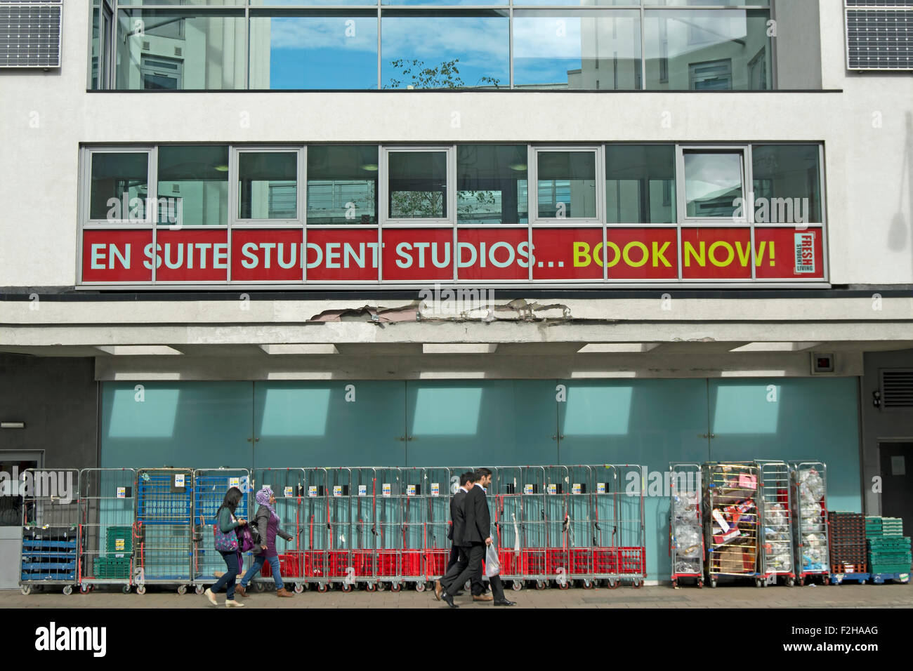 Fußgänger fahren Sie unter einem Banner-Werbung für studentisches Wohnen in Kingston nach Themse, Surrey, england Stockfoto