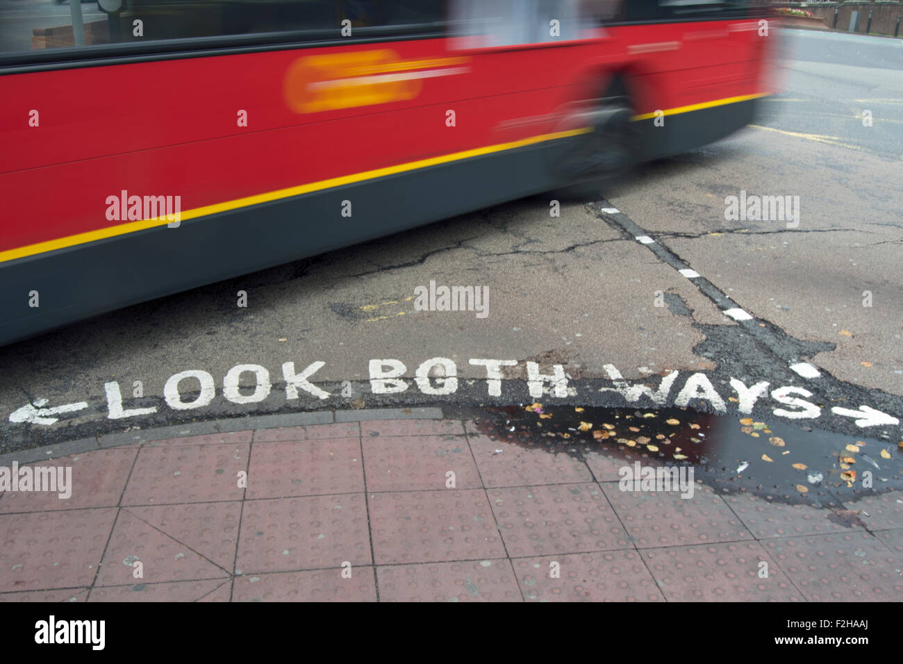 Schauen Sie beide Richtungen Straßenschild mit Bus in Bewegungsunschärfe, Kingston nach Themse, Surrey, England Stockfoto