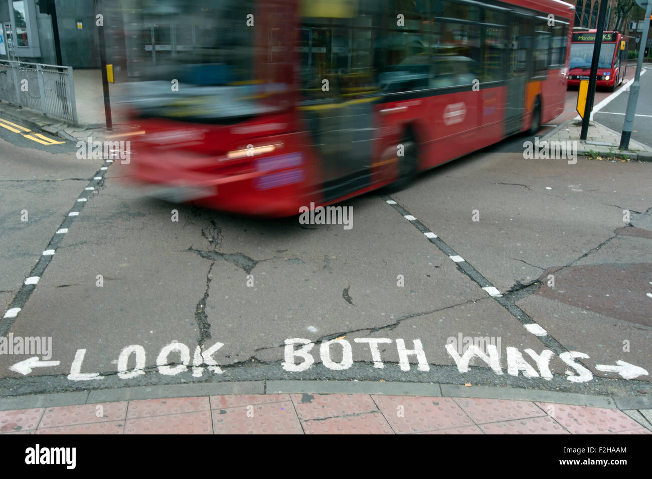 Schauen Sie beide Richtungen Straßenschild mit Bus in Bewegungsunschärfe, Kingston nach Themse, Surrey, England Stockfoto