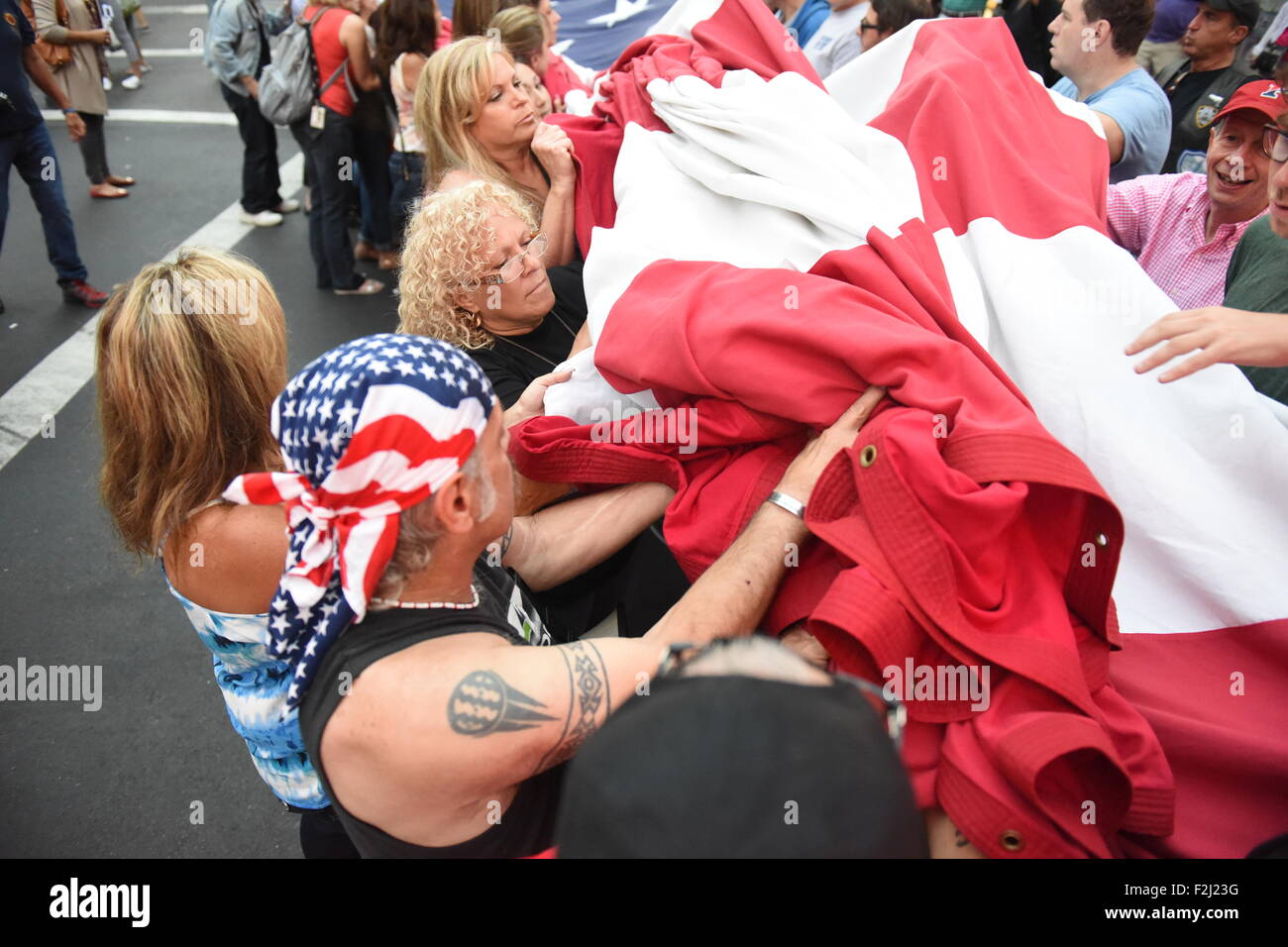 New York City, USA. 19. Sep, 2015. Falten große Fahne mit Sorgfalt. Absetzung und Faltung des Ground Zero-Flag ist eine jährliche Zeremonie an der Mott Street an der Ecke von Hester geworden. Bildnachweis: Andy Katz/Pacific Press/Alamy Live-Nachrichten Stockfoto