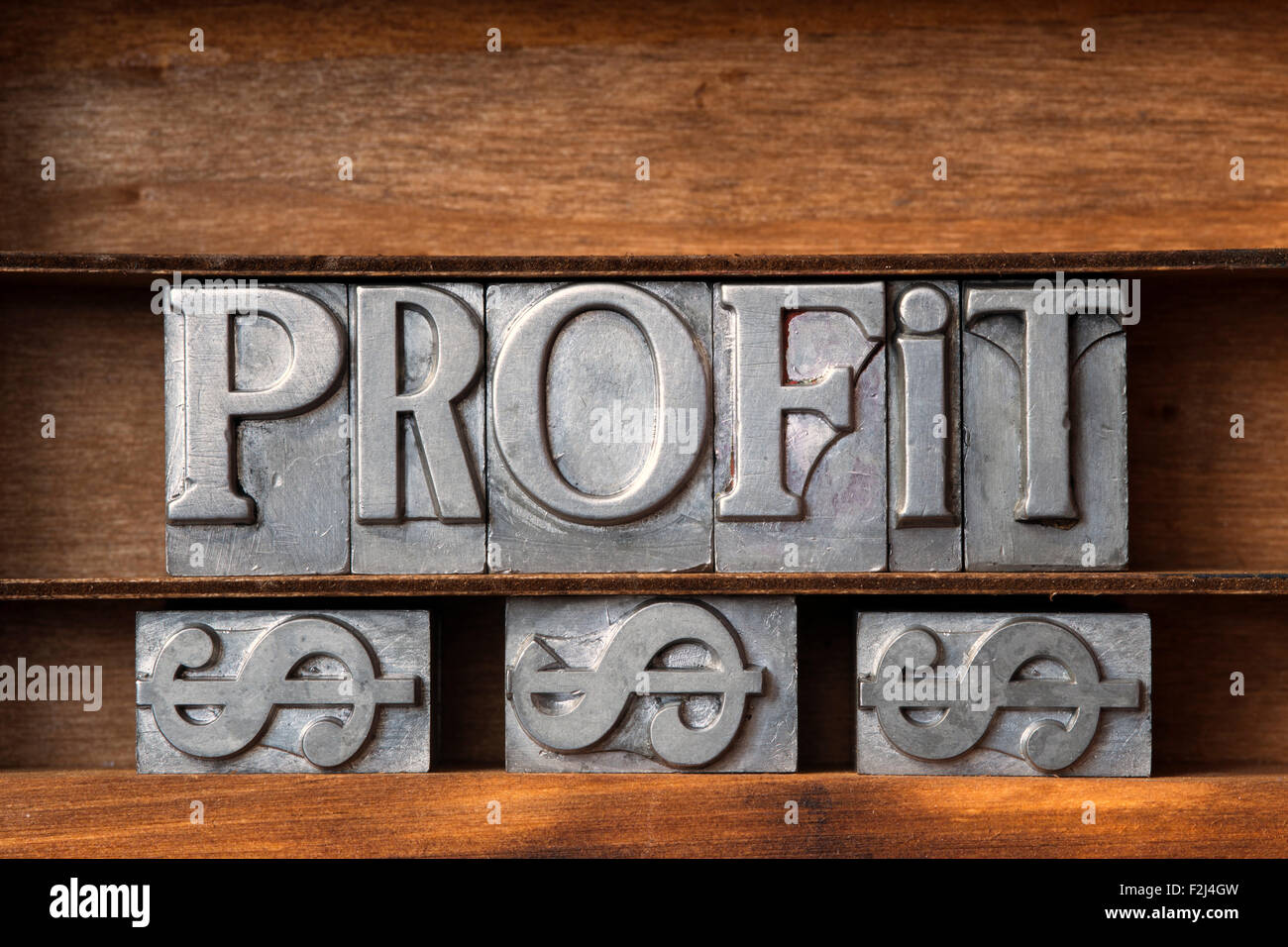 Gewinn-Wort mit Dollar-Zeichen aus metallischen Buchdruck auf Tablett aus Holz hergestellt Stockfoto