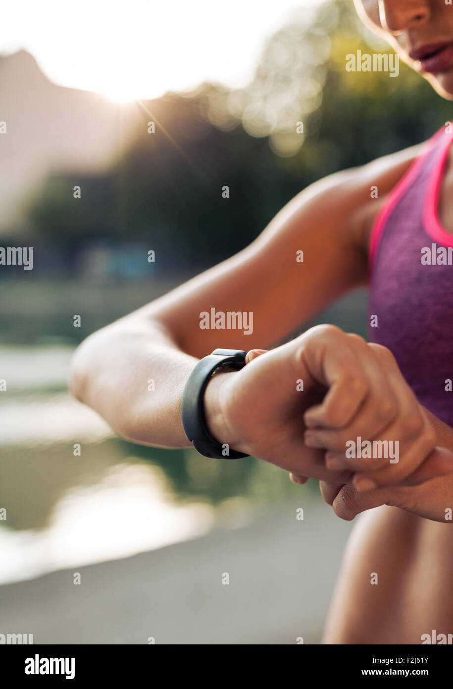 Schuss von junge Frau Jogger startbereit festlegen und auf der Suche bei Sport Smartwatch hautnah. Fitness Frauen überprüfen ihre Leistung. Stockfoto