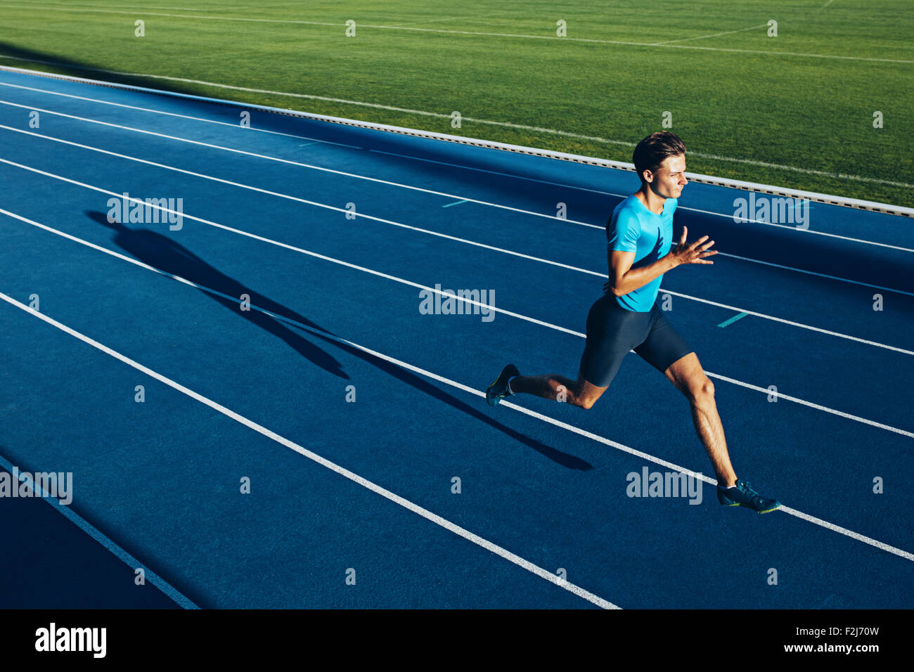 Aufnahme eines jungen männlichen Athleten training auf der Rennstrecke. Sprinter läuft auf Leichtathletik verfolgt. Stockfoto