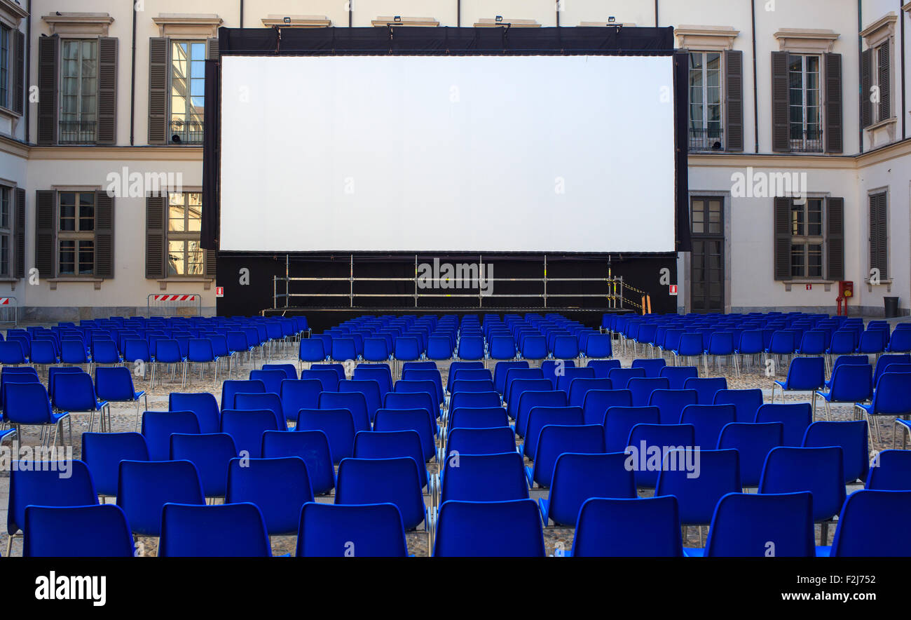 Blick auf Bildschirm und leere blaue Stühle für Open Air Kino Stockfoto