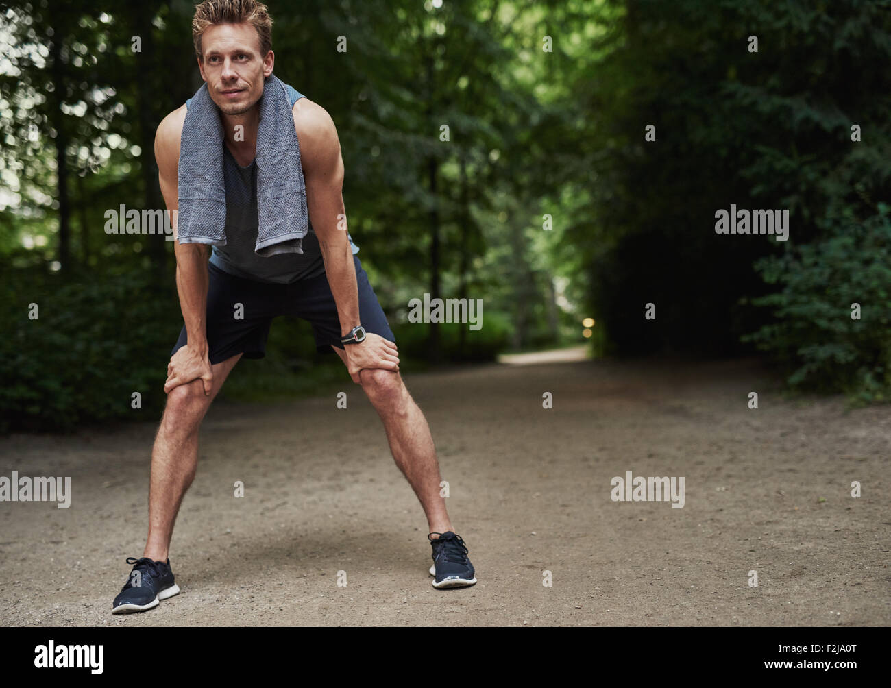 Passen Sie junge Mann hält seine Knie während ruht nach ein laufen Übung im Park. Stockfoto