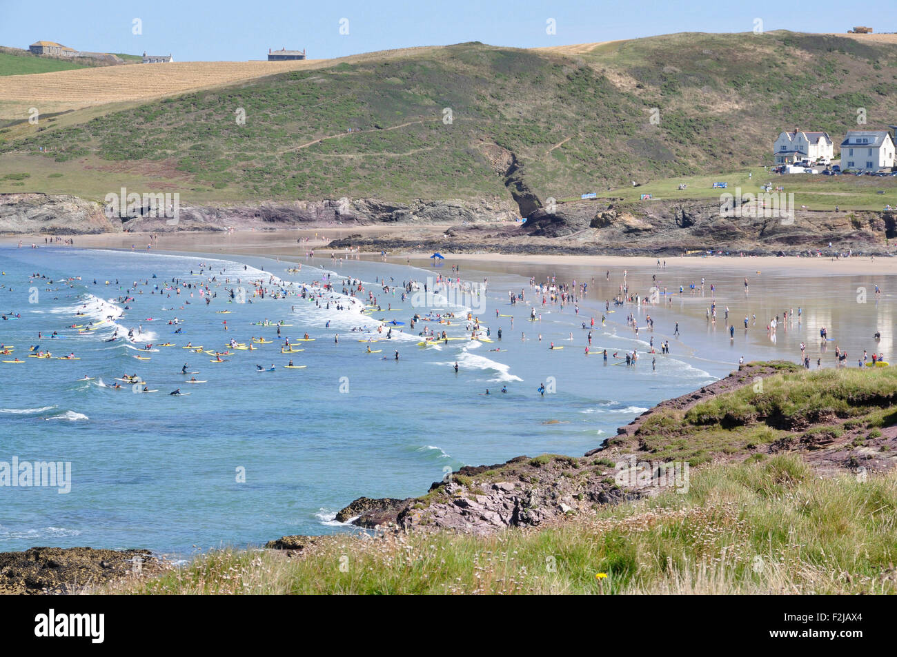 North Cornwall - Polzeath - Strand von Klippen über der Bucht - brechen weiße Spitze Wellen - Surfer - Sonnenlicht blauen Himmel + Meer Stockfoto
