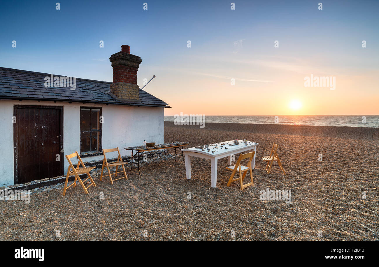 Ein Tisch und Stühle bei Sonnenaufgang am Strand von Aldeburgh in Suffolk Stockfoto