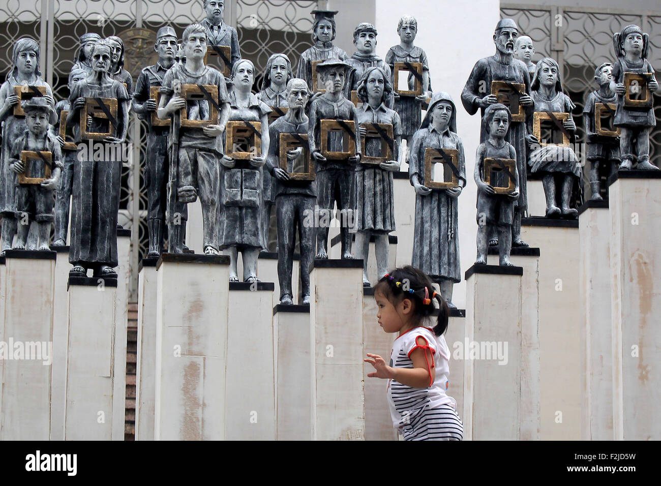 Quezon City, Philippinen. 20. Sep, 2015. Eine Mädchen spielt vor Installation Kunst an der Universität der Philippinen in Quezon City, Philippinen, 20. September 2015 angezeigt. Die Installationskunst erfolgt unter Beachtung der Jahrestag der Verhängung des Kriegsrechts und die Opfer von Verschleppungen oder "Desaparecidos" verewigt. © Rouelle Umali/Xinhua/Alamy Live-Nachrichten Stockfoto