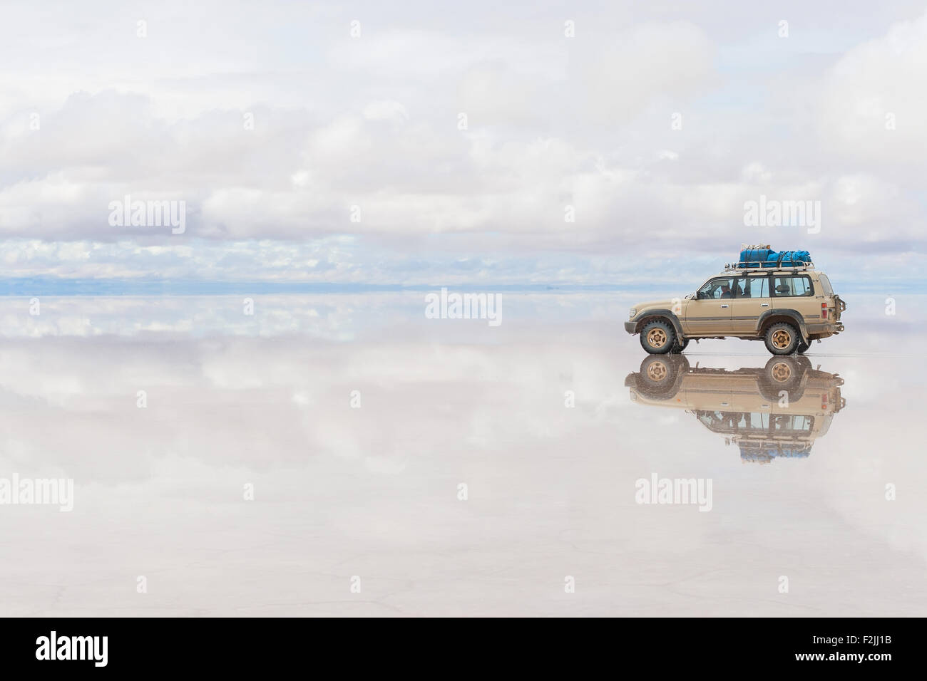 Offroad-Fahrzeug auf die reflektierte Oberfläche des Sees Salar de Uyuni in Bolivien Stockfoto