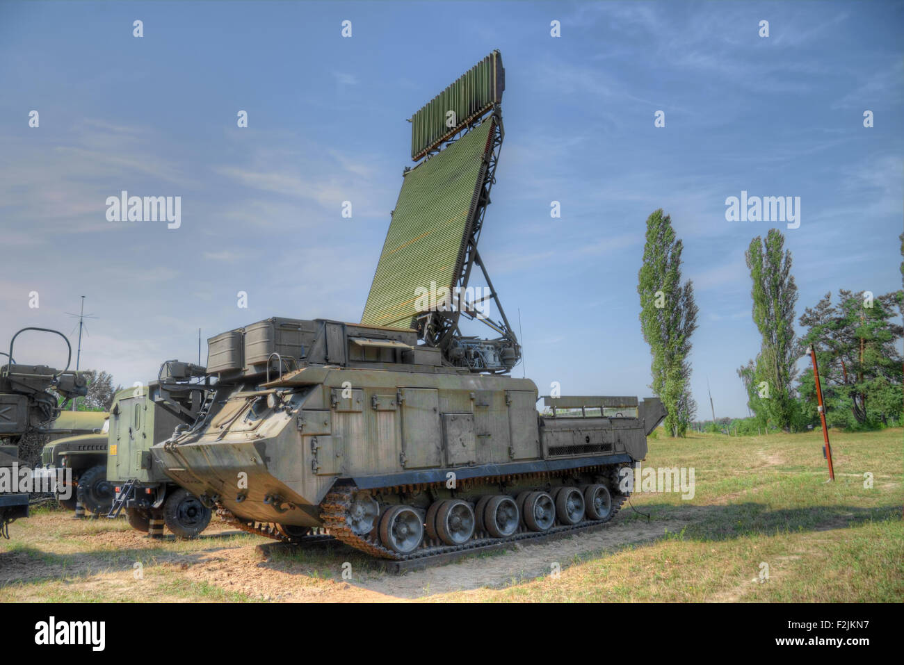 Mobile Radarstation und andere Fahrzeuge auf Position am Waldrand Stockfoto