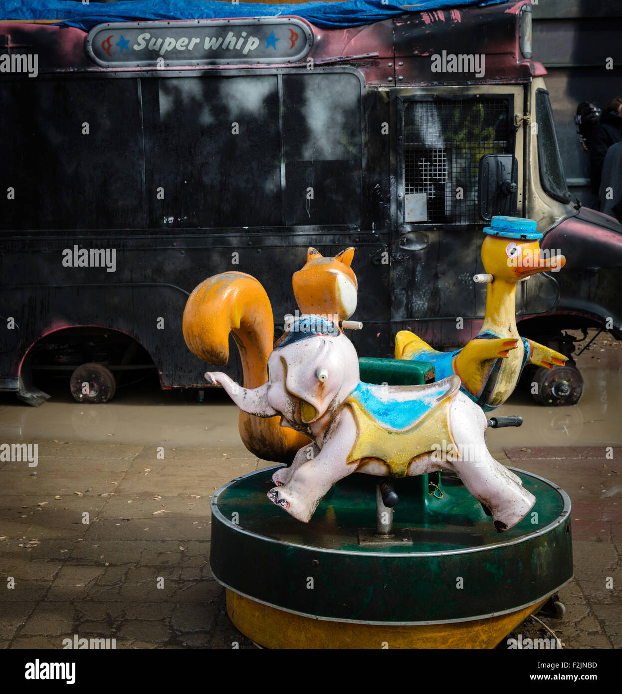 Kinderkarussell traurig heruntergekommenen Tiere vor einem ausgebrannten Eis van bei Banksy Dismaland in Weston Super Mare Stockfoto