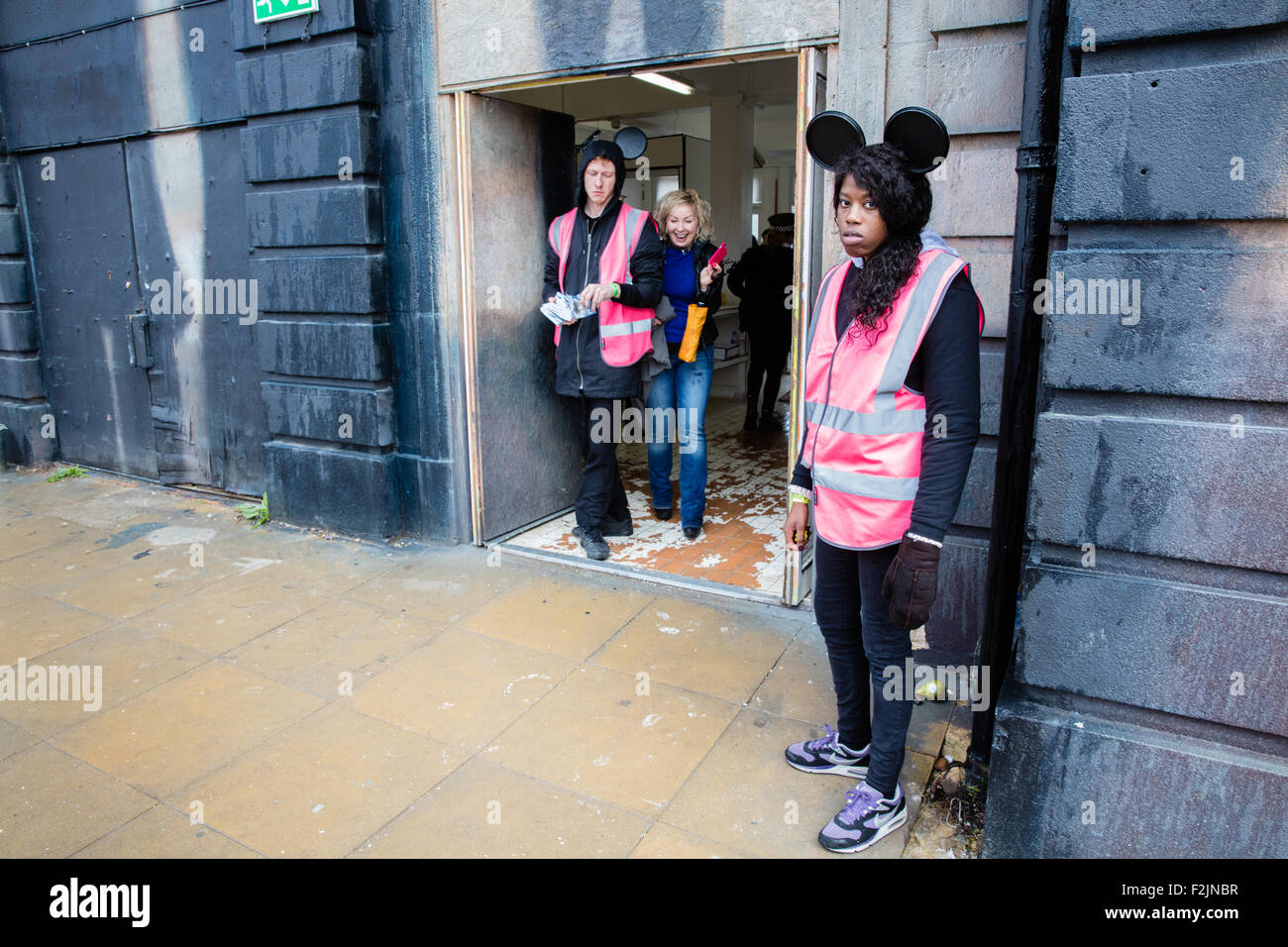 Freundlichen und hilfsbereiten Mitarbeiter begrüßen die Besucher zu Dismaland der dystopischen Banksy Themenpark in Weston Super Mare UK Stockfoto