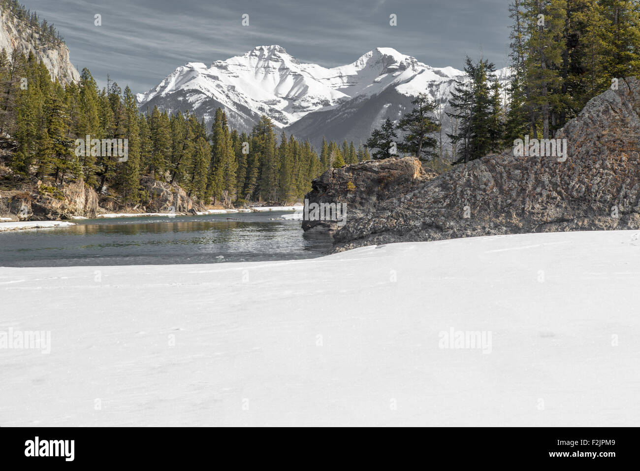 Bow River Banff Kanada im Frühjahr mit Schnee Rocky Mountains im Hintergrund begrenzt. Stockfoto