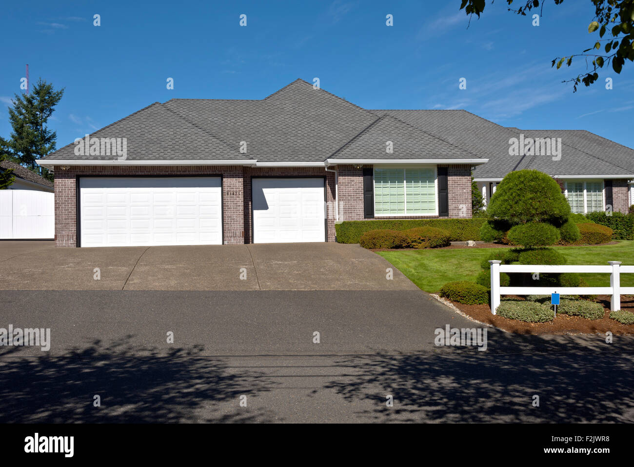 Großes Haus mit weißen Zäunen und gepflegten Rasen Oregon. Stockfoto