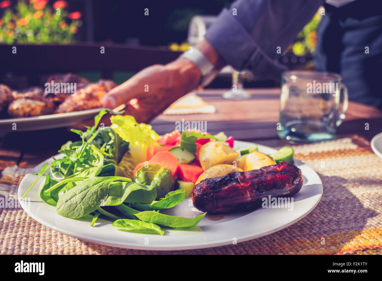 Wurst und Salat auf einem Teller außerhalb t Familie Grill Stockfoto