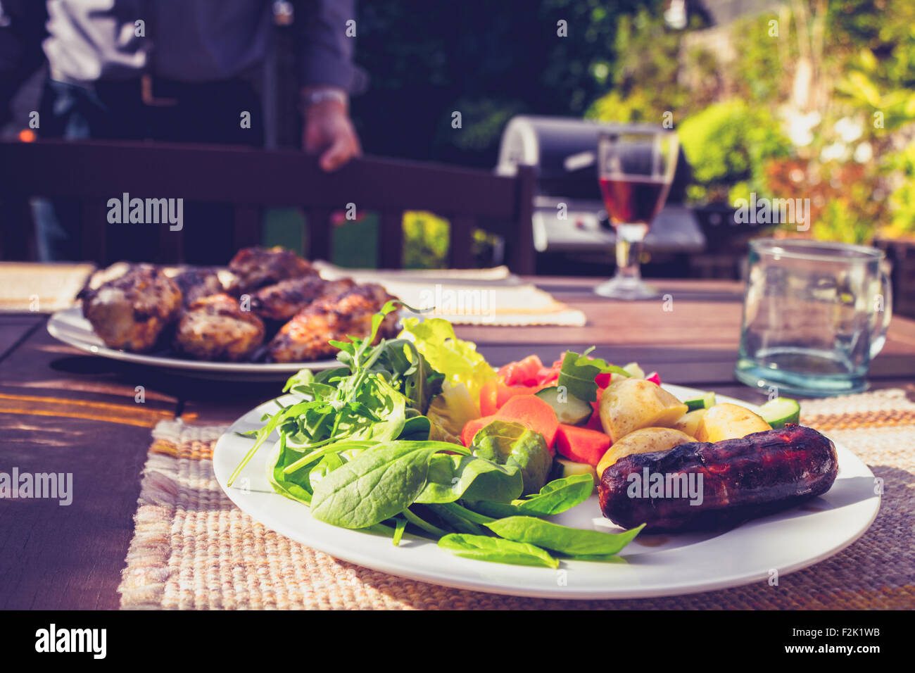 Wurst Fleisch und Salat auf einem Tisch im Garten am Grill Stockfoto
