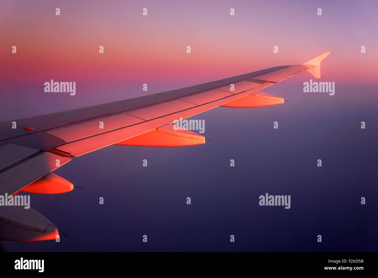 Passagier-Jet Flugzeugflügel fliegen durch Sonnenuntergang Himmel, Airbus A 320. Stockfoto