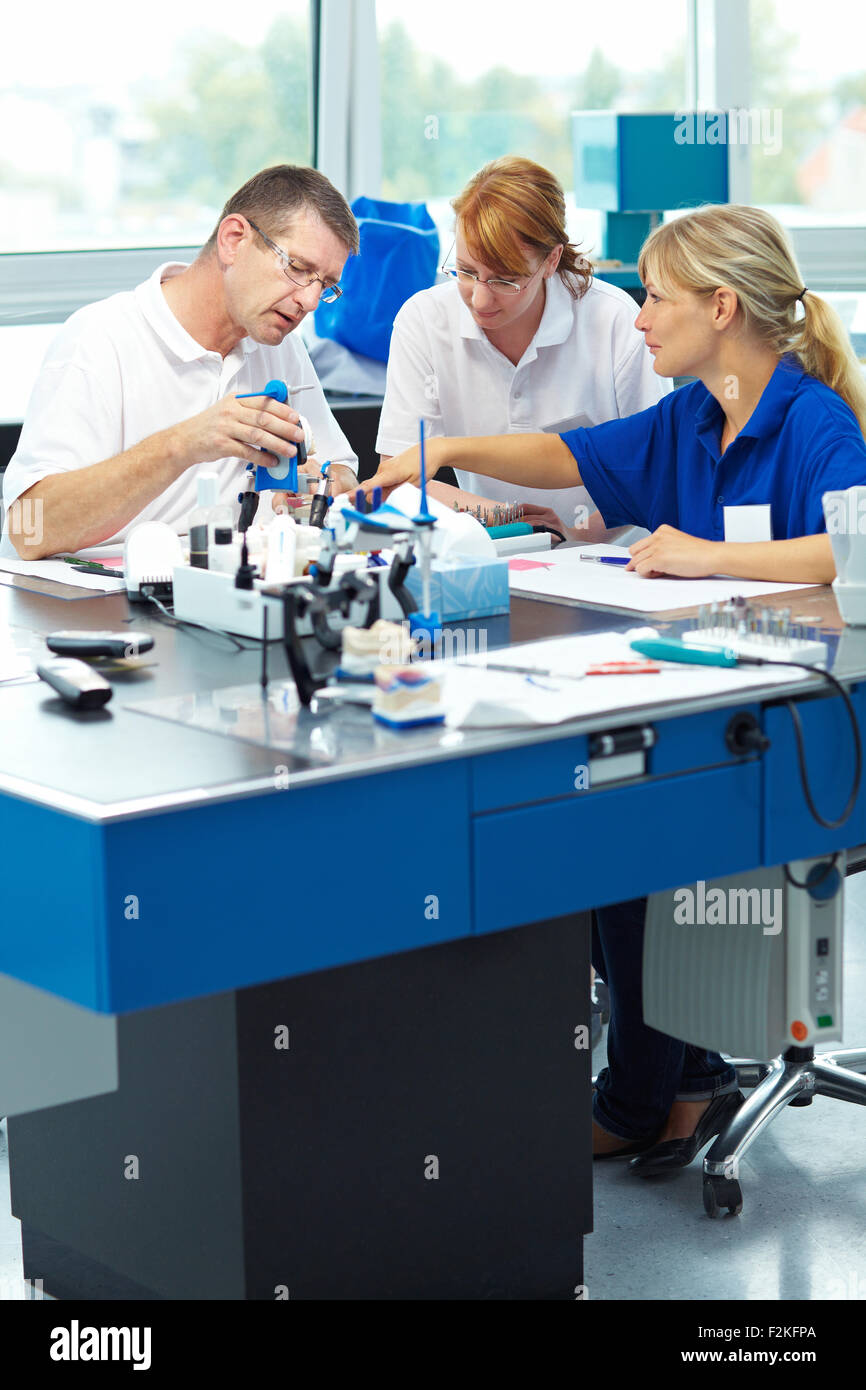 Drei Zahntechniker arbeiten in einem zahntechnischen Labor Stockfoto