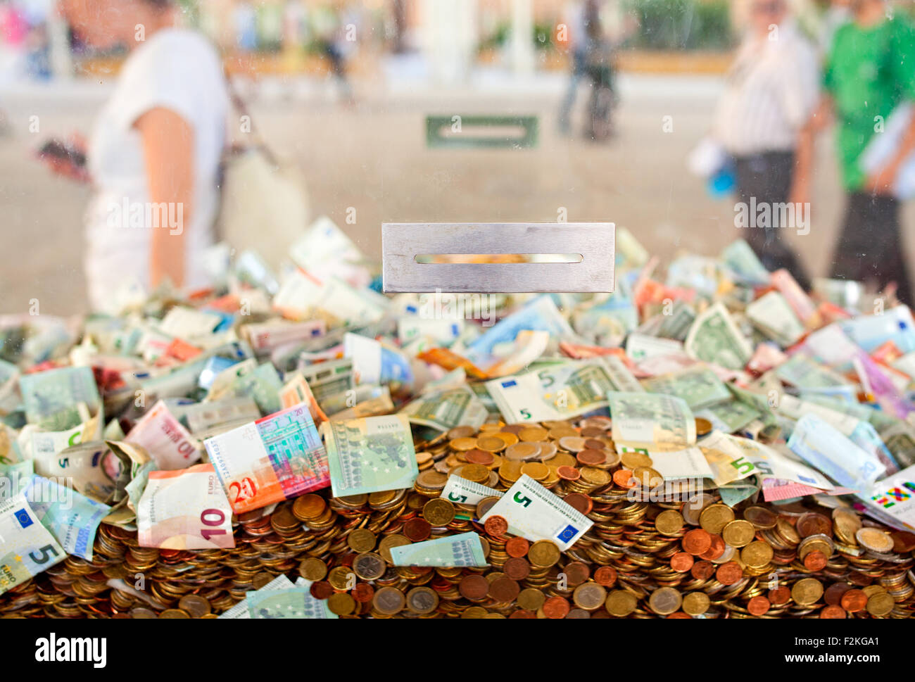 Blick auf viele Papiergeld im Inneren des Würfels Plexiglas für Fundraising Stockfoto