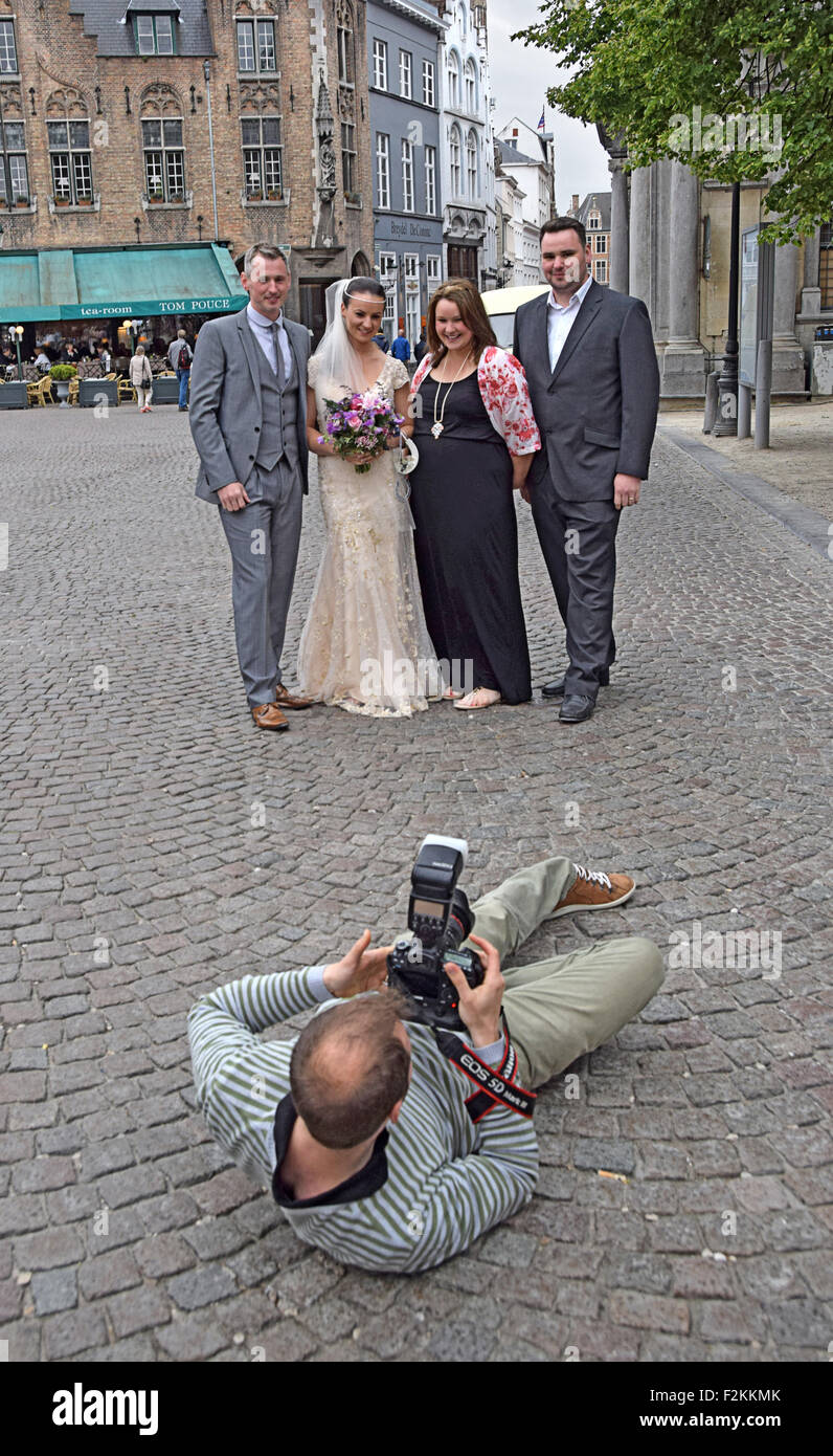Hochzeitsfotograf liegt auf dem Boden zu einem besseren Winkel in Brügge, Belgien. Stockfoto