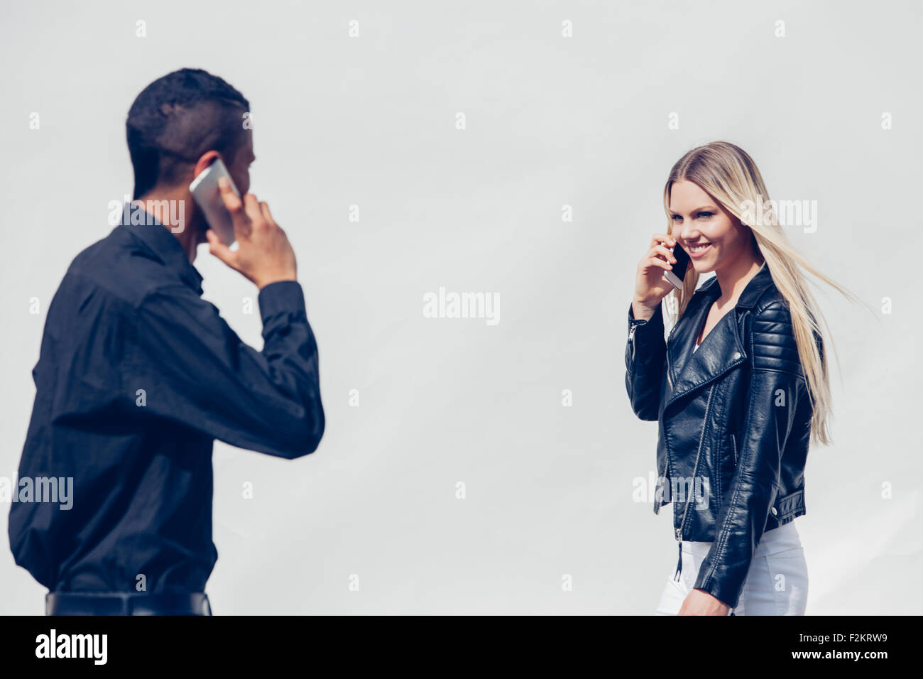 Zwei junge Leute telefonieren mit Smartphones belauern Stockfoto