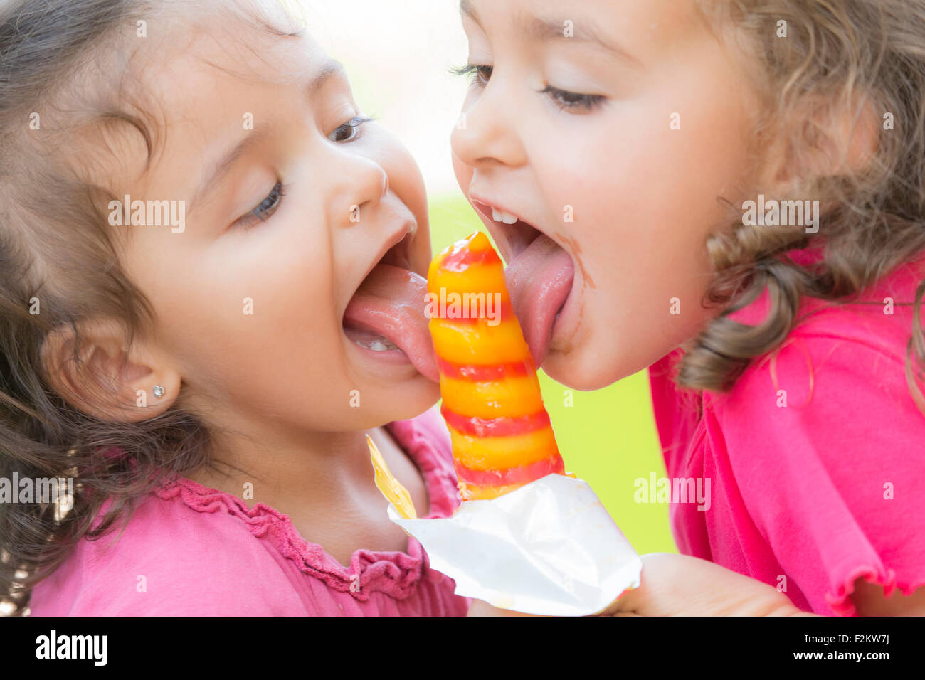 Zwei kleine Schwestern gemeinsam essen ein Eis am Stiel Stockfoto