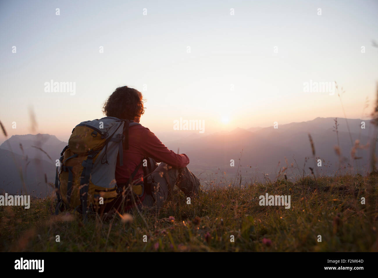 Österreich, Tirol, Unterberghorn, Wanderer ruht in alpiner Landschaft bei Sonnenuntergang Stockfoto