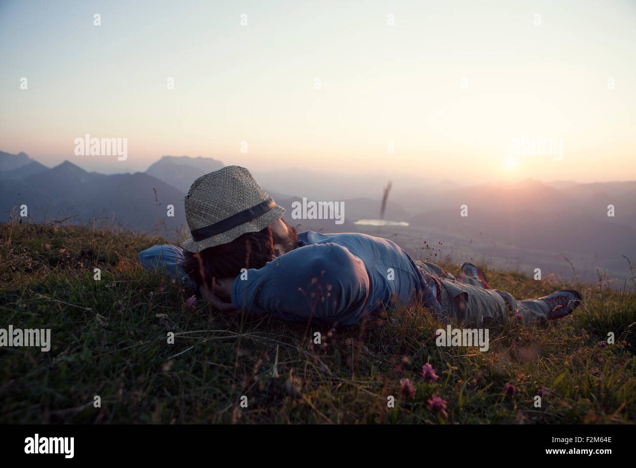 Österreich, Tirol, Unterberghorn, Mann entspannend auf Alp bei Sonnenuntergang Stockfoto