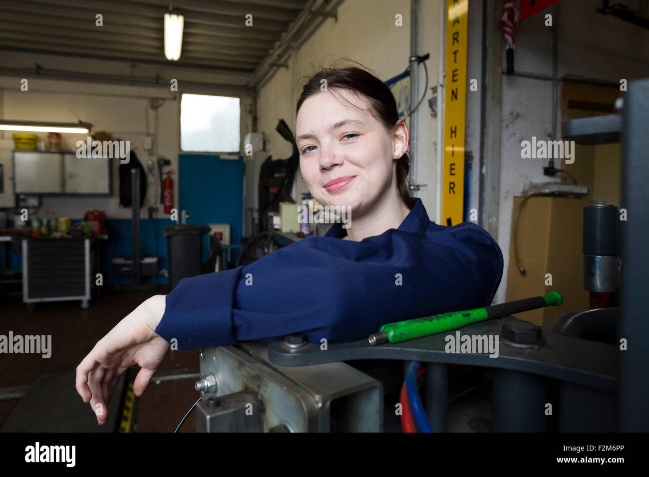 Junge Frau arbeiten in Werkstatt, Blick in die Kamera Stockfoto