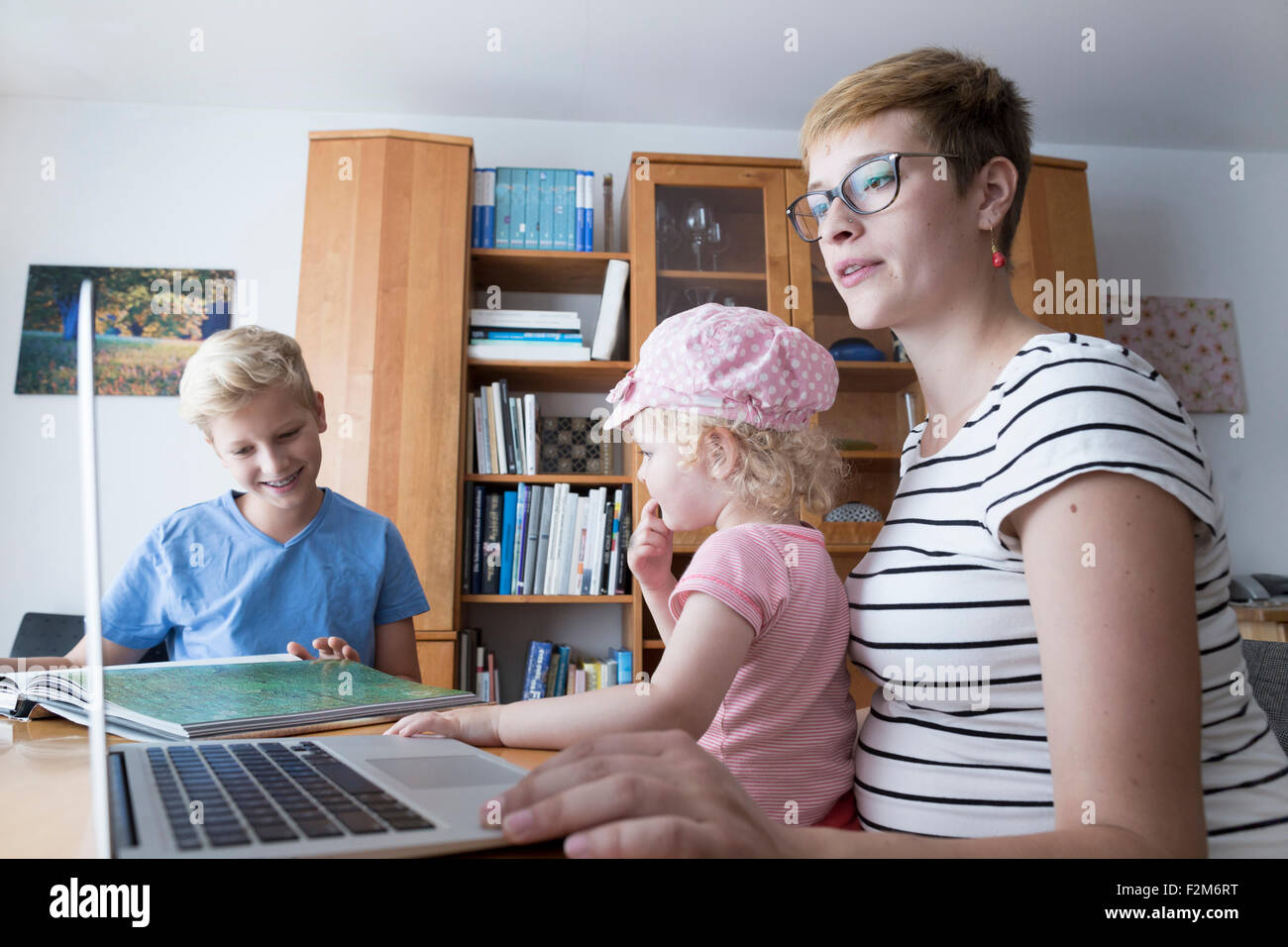 Schwangere Frau mit Sohn und Tochter mittels zu Hause laptop Stockfoto