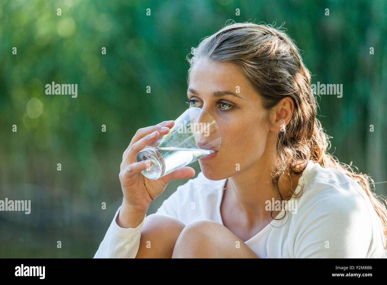 Schöne Frau mit nassen Haaren Glas Wasser trinken Stockfoto