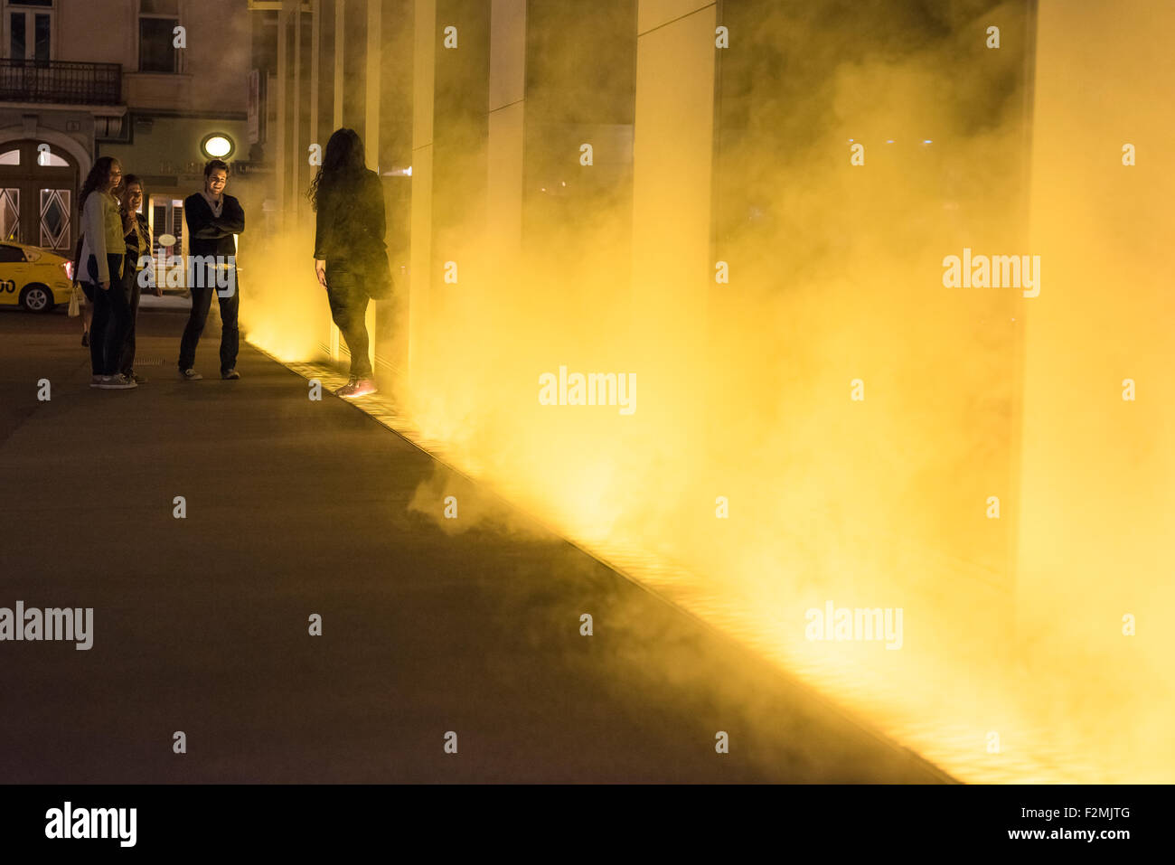 Street Art Wien, Menschen in Wien halten inne, um Yellow Fog, eine öffentliche Kunstinstallation von Olafur Eliasson, Wien, Österreich, zu sehen. Stockfoto