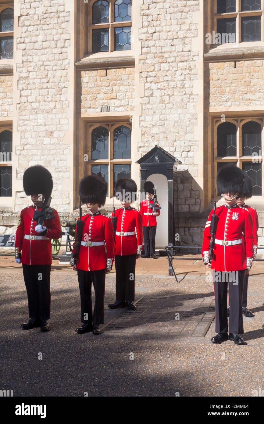 Zeremonie des Wortes mit Gardisten auf Parade, die traditionellen roten Uniformen und Bärenfell tragen Hüte Tower of London Stadt von London Stockfoto