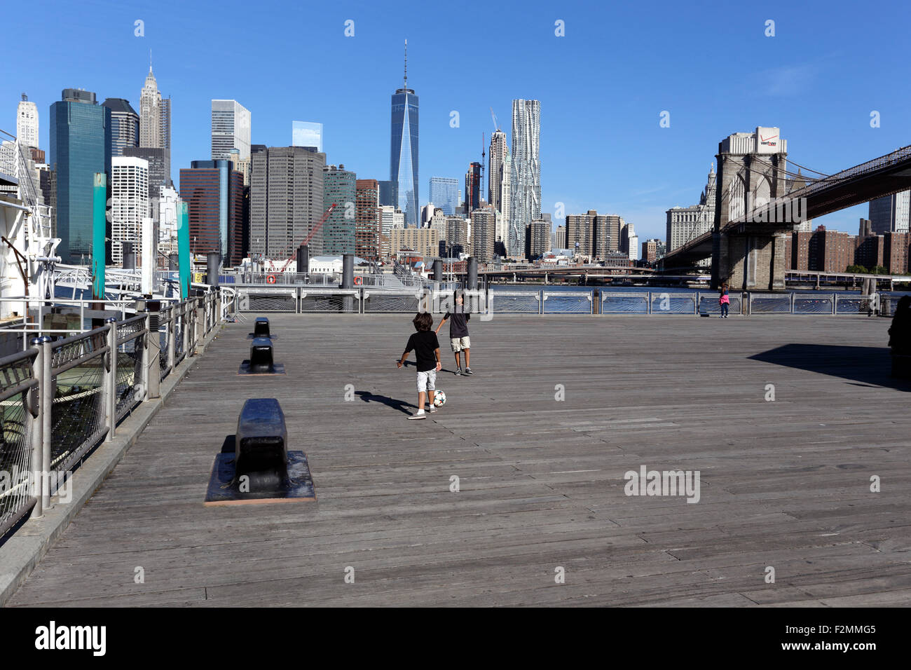 Fußballspielen unter der Brooklyn Bridge im Fulton Landing Park Brooklyn New York City Stockfoto