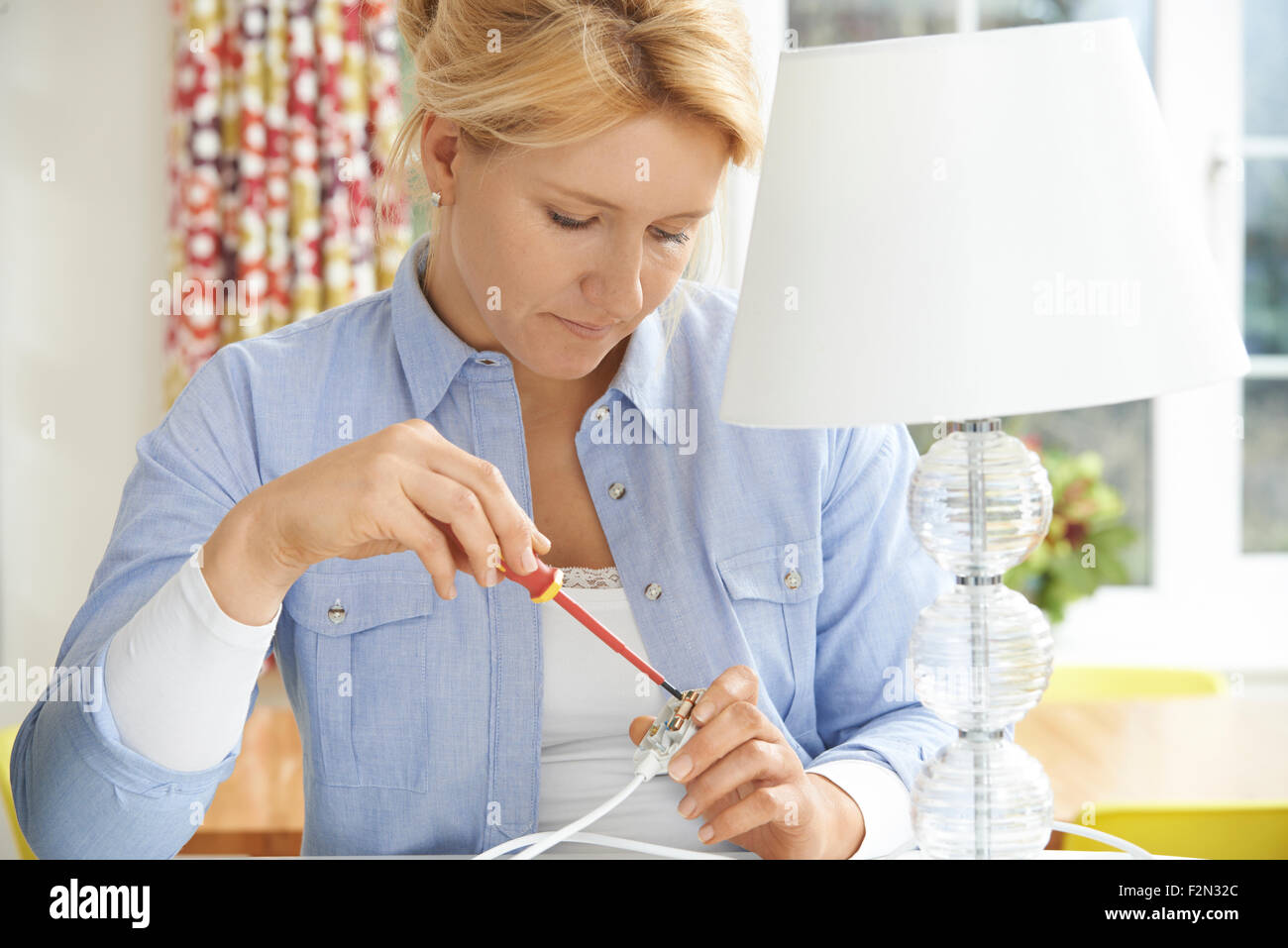 Frau Verkabelung Steckdose Lampe zu Hause Stockfoto