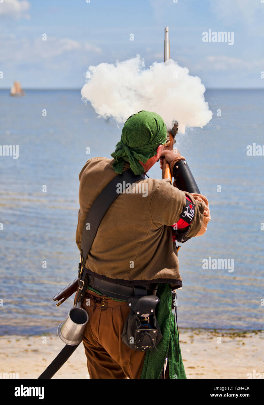 Ein Pirat Reenactor stehen am Strand während des Cedar Key Piraten Festivals an der Golfküste sein Steinschloss Gewehr schießen Stockfoto
